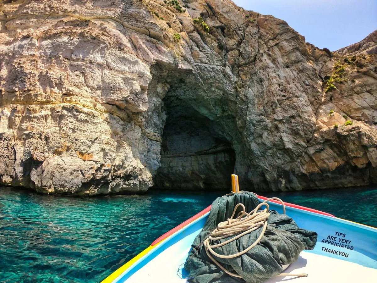 view of the bow of a small boat approaching the blue lagoon in malta
