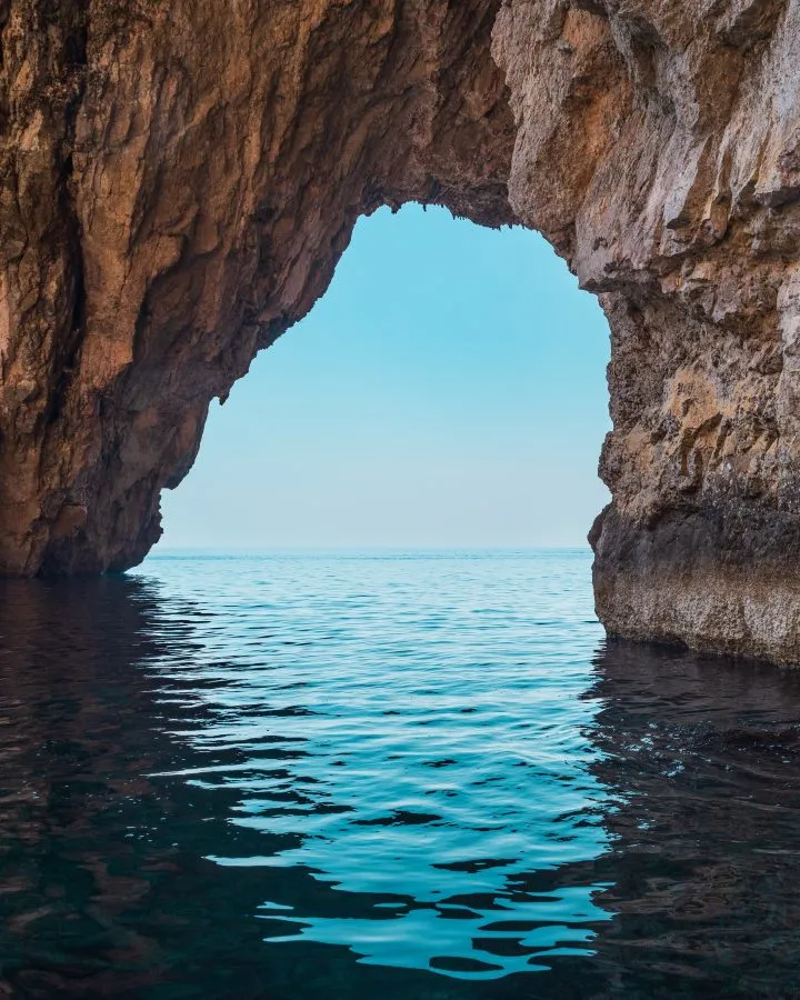 view from inside malta blue grotto with arch looking out toward the sea
