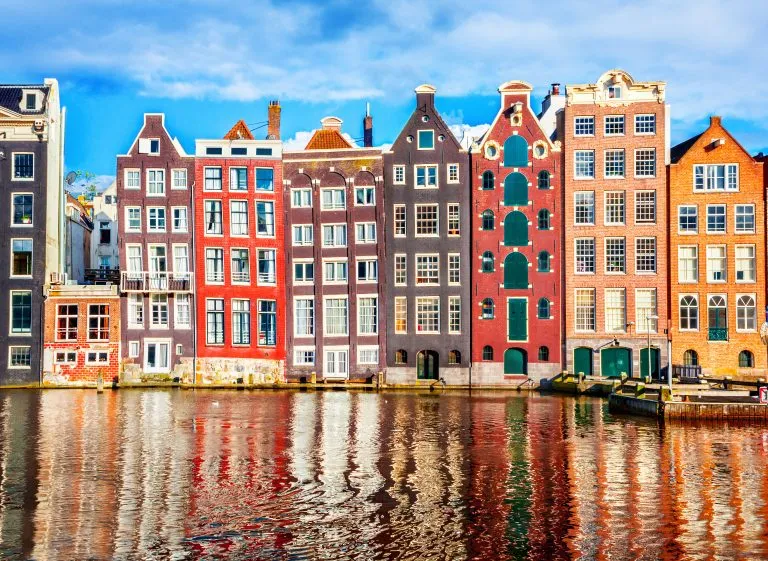 collection of colorful buildings along a canal in amsterdam april travel guide