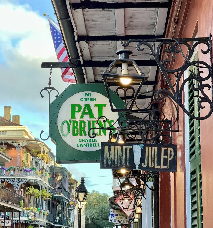 collection of signs in the french quarter nola, one closest to camera says mint julep