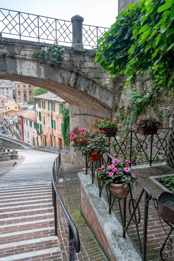 view of beginning of walkway of medieval aqueduct in perugia with historic bridge over it