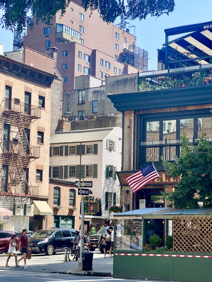 shady street in manhattan nyc showing a restaurant, a brownstone and a colonial style building