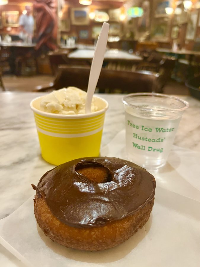 doughnut with chocolate frosting, vanilla ice cream, and plastic water cup on a table at wall drug in wall south dakota