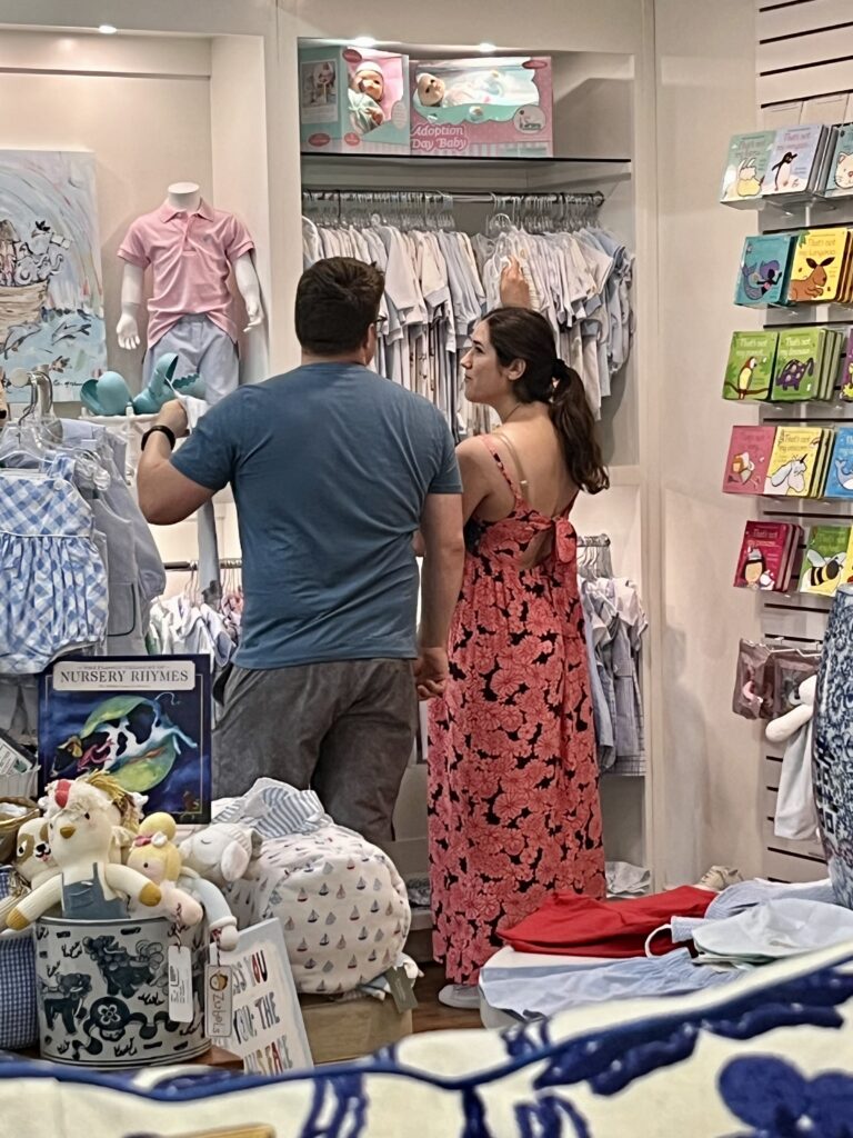 kate storm and jeremy storm looking at baby clothes in deegees when shopping in morehead city